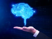 Businessman hand holding glowing digital brain.